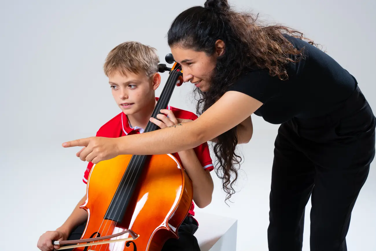 Music District Dubai instrument specialist guiding a young cellist