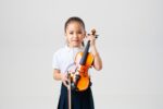 Young student holding a SOMON violin - Music District Dubai