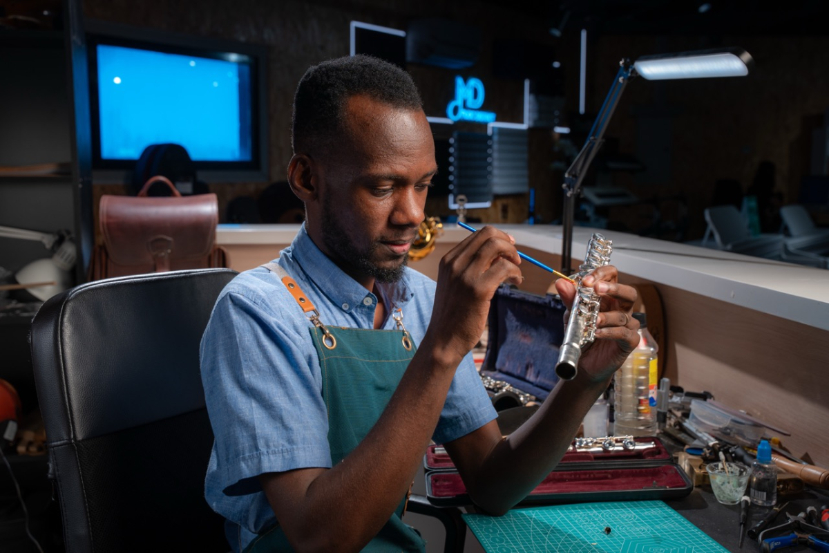 Nicholas repairing a woodwind instrument at his workshop bench