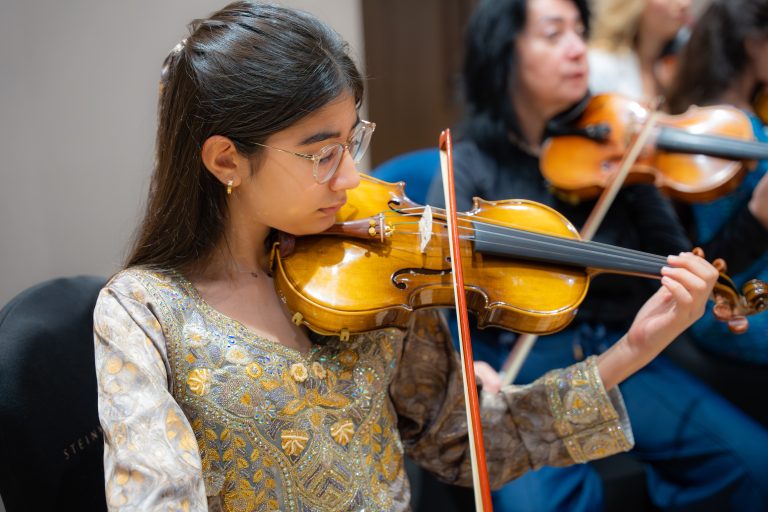 Young violinist at an Empowering Emirati Musicians Program rehearsal