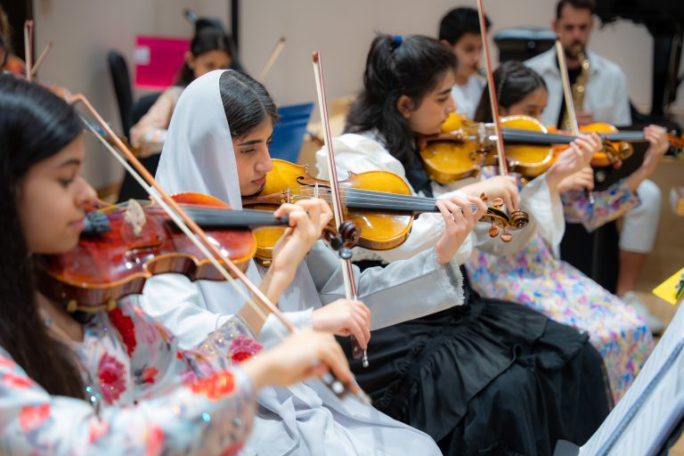 Violinists rehearsing as an ensemble in the Empowering Emirati Musicians Program